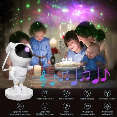 White Astronaut Galaxy Projector placed near a birthday cake illuminating a family room with star lights.