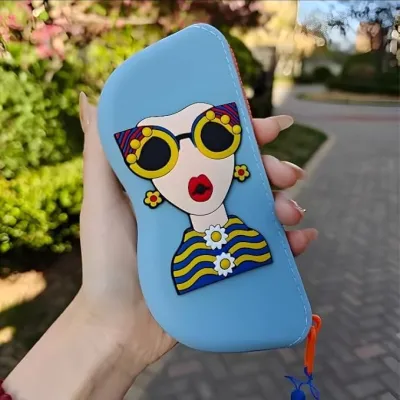 A person holding a light blue Cartoon Sunglasses Case in hand outdoors with green foliage blurred behind.