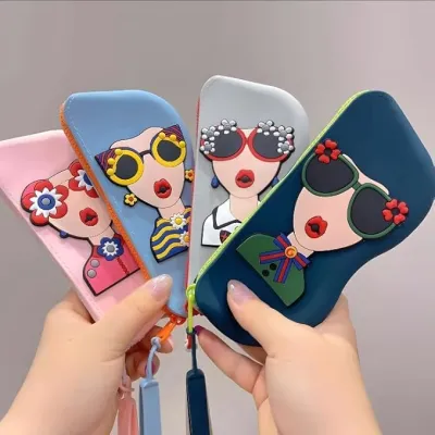 Hands holding four different colorful Cartoon Sunglasses Case silicone pouches fanned out against a gray wall.