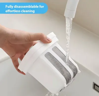 A hand holding the white mesh inner filter of a Greek Yogurt Strainer under running tap water to wash it.
