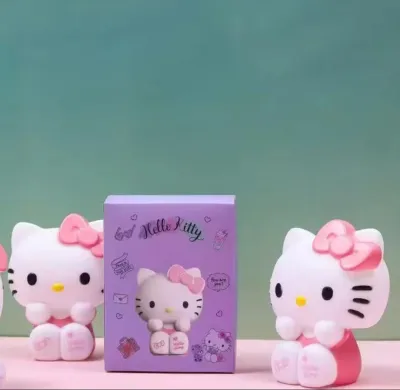 Hello Kitty Silicone Night Lamp set next to its purple retail packaging box on a desk.