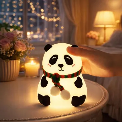 A hand tapping a Panda Silicone Night Light glowing warm white on a bedside table.
