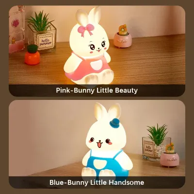 Pink Silicone Bunny Night Light emitting soft warm yellow light on a wooden table beside small plants.