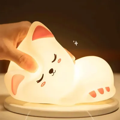 Hand squishing the soft squishy silicone cat night lamp demonstrating its flexible silicone material.