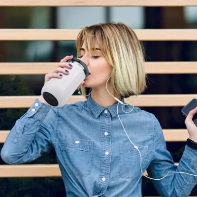 Woman drinking from the white Vacuum Insulated Coffee Mug 350ml while wearing a denim shirt